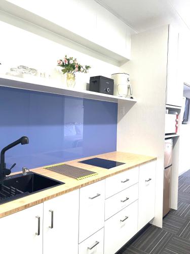 a kitchen with white cabinets and a counter top at Amber Lake D in Auckland