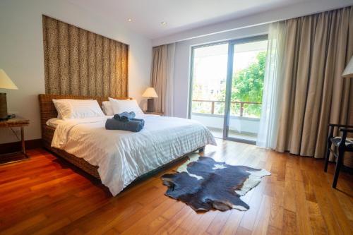 a bedroom with a bed and a large window at Suite of Naithon beachfront apartment in Nai Thon Beach