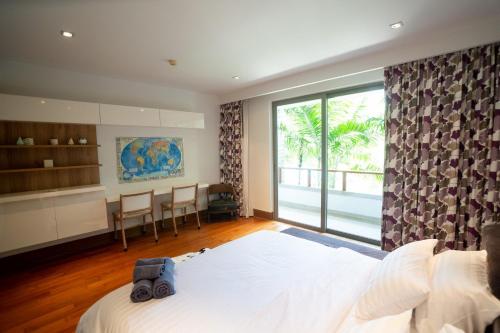 a bedroom with a large bed and a large window at Suite of Naithon beachfront apartment in Nai Thon Beach