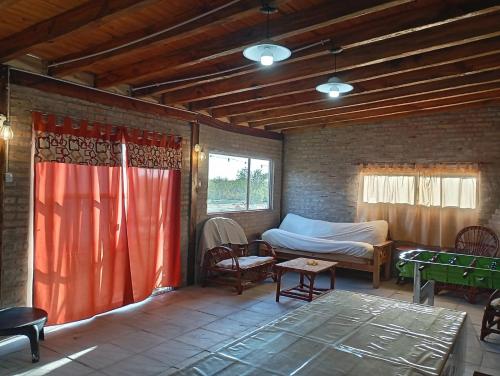 ein Zimmer mit einem Bett, einem Tisch und einer Couch in der Unterkunft El Retoño in Esquina