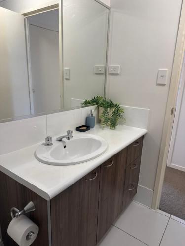a bathroom with a sink and a mirror at Serenity Stay Brisbane in North Lakes