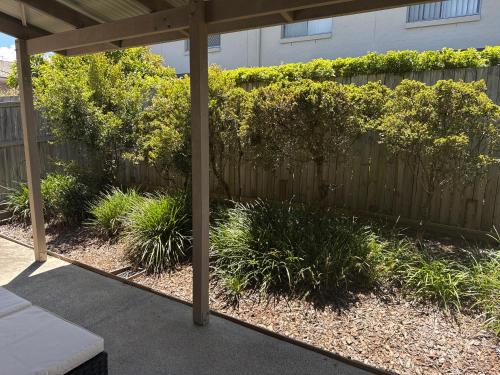 a patio with a wooden fence and plants at Serenity Stay Brisbane in North Lakes