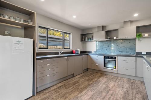 a kitchen with white cabinets and blue marble counter tops at Tasman Holiday Parks - Te Anau in Te Anau