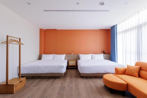 a hotel room with two beds and a couch at Richen Shanshan in Chün-hsin