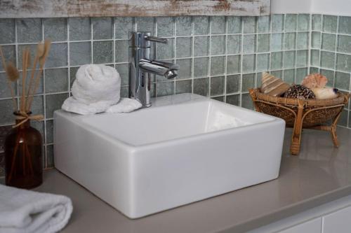 a white sink in a bathroom with a faucet at Harrington Gerroa in Gerroa