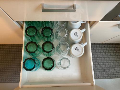 a drawer filled with glass bowls and cups at HOUS-AGALonomichi in Onomichi
