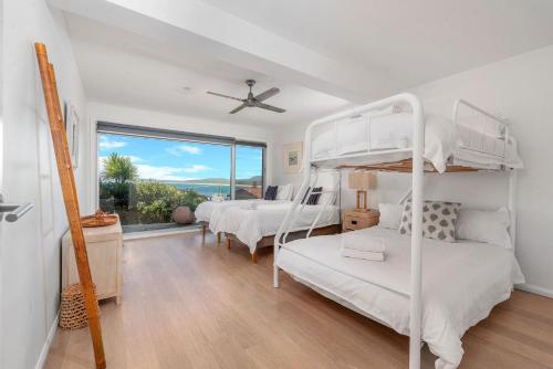 a bedroom with two bunk beds and a window at Harrington Gerroa in Gerroa