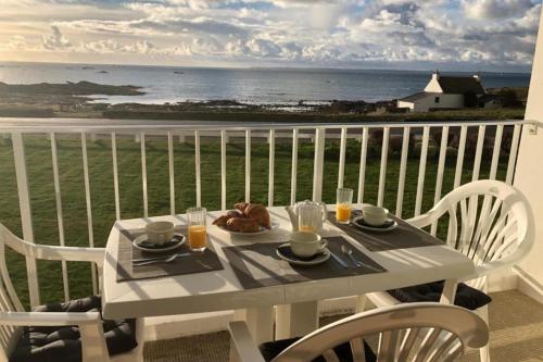 - une table blanche avec de la nourriture sur un balcon donnant sur l'océan dans l'établissement Studio les 3 iles vue mer N42, à Quiberon
