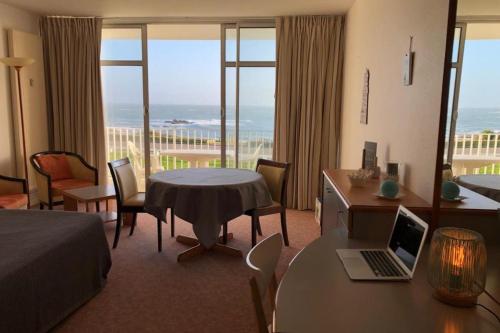 une chambre d'hôtel avec un lit et une table avec un ordinateur portable dans l'établissement Studio les 3 iles vue mer N42, à Quiberon
