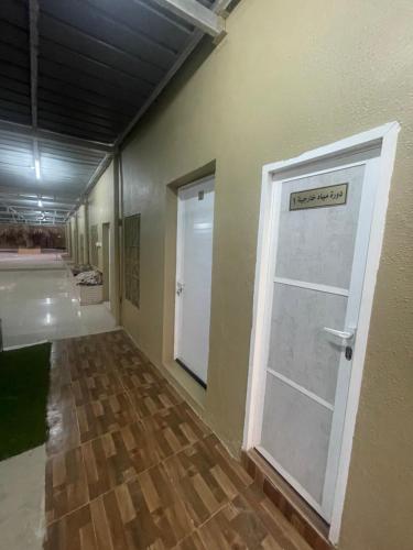 a hallway with a white door in a room at نزل نسيم الحمراء - nseem alhamra inn in Al Ḩamrāʼ