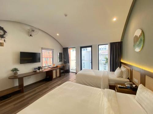 a hotel room with two beds and a television at A25 Hotel - 14 Hồ Huấn Nghiệp in Ho Chi Minh City