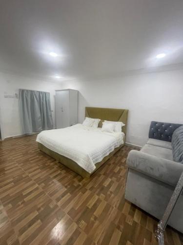 a bedroom with a bed and a couch at نزل نسيم الحمراء - nseem alhamra inn in Al Ḩamrāʼ