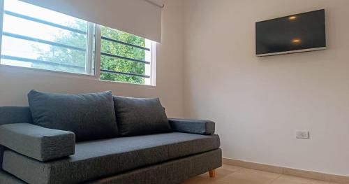Una sala de estar con un sofá y un televisor de pantalla plana. en El Buen Vivir, en Mar del Plata