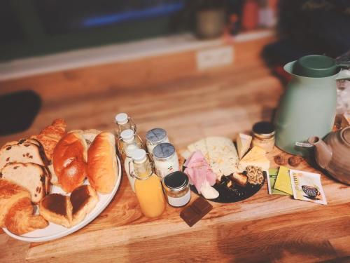a table topped with a plate of bread and condiments at La nuitée à la ferme in Érezée