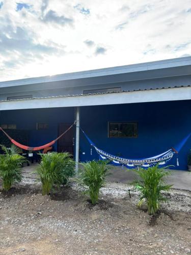 a blue building with a hammock in front of it at Casa Celeste Río Grande in Paquera
