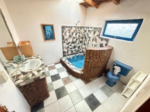a bathroom with a tub and a sink and a toilet at Atacama Lodge Rukazen Rústico in San Pedro de Atacama