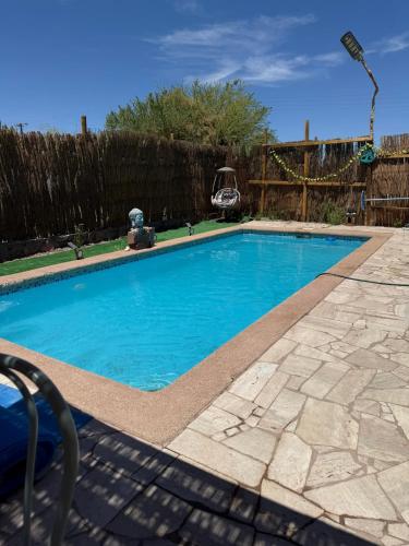 a swimming pool with blue water in a yard at Atacama Lodge Rukazen Rústico in San Pedro de Atacama