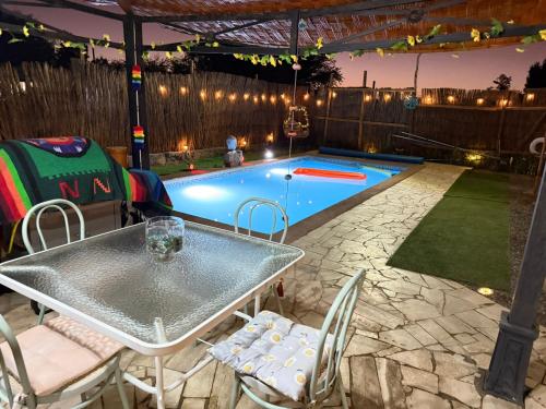 a patio with a table and chairs next to a swimming pool at Atacama Lodge Rukazen Rústico in San Pedro de Atacama