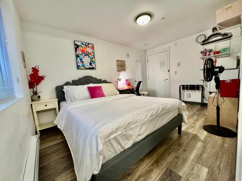 Un dormitorio con una gran cama blanca y un escritorio. en Micro Studio Apartment 10 Minutes Walk To University of Washington, en Seattle