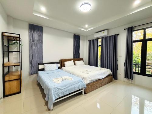 a bedroom with two beds and a window at Winlanee Pool Villa Hatyai in Ban Khlong Toei (1)
