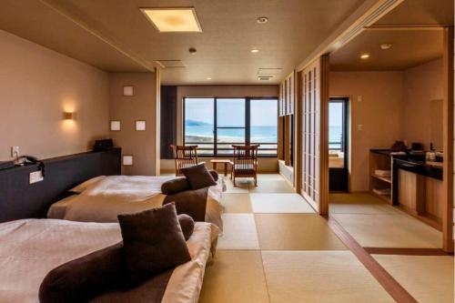 a bedroom with two beds and a couch and a table at Ichiboukan Hanare Kai in Kyotango