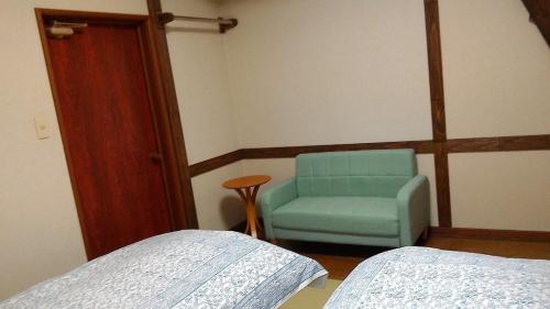 a bedroom with a blue chair next to a bed at Minamiuonuma - Hotel - Vacation STAY 36035v in Minami Uonuma