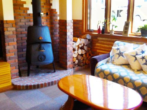a living room with a fireplace with a couch and a stove at Pension Come Healing Tatami-room- Vacation STAY 14980 in Minami Uonuma