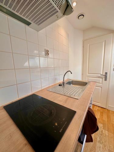 une cuisine avec un évier et un plan de travail dans l'établissement Appartement Cosy avec Netflix et parking gratuit, à Montataire