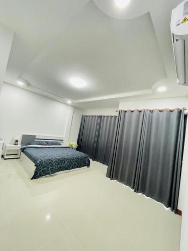 a bedroom with a bed and a window with curtains at Gips Home in Ban Mae Hom