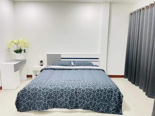 a bedroom with a bed with a blue comforter at Gips Home in Ban Mae Hom