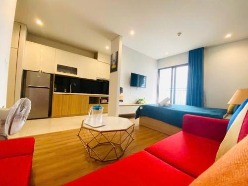 a living room with a red couch and a kitchen at Golden sunshine studio-Sea view &Nelflix Free in Ha Long
