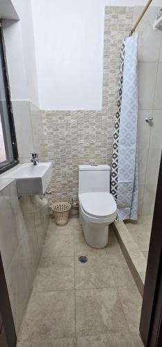 a bathroom with a toilet and a sink at La Frontera Departamento in Tulcán