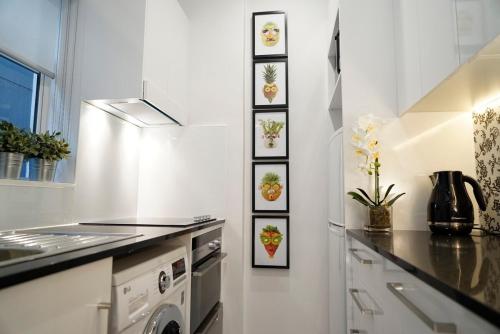 a white kitchen with a sink and a stove at Perfect Potts Point Pied-à-terre in Sydney