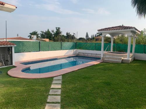 a swimming pool in a yard with a gazebo at Residencia con alberca privada y jacuzzi en Lomas de Cocoyoc in Oaxtepec