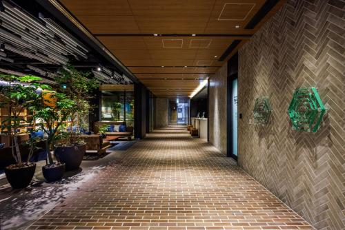 an empty hallway in a building with potted plants at &Here TOKYO UENO in Tokyo