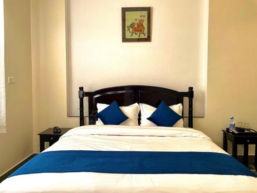 a bedroom with a bed with blue and white pillows at Tasya Villa in Udaipur