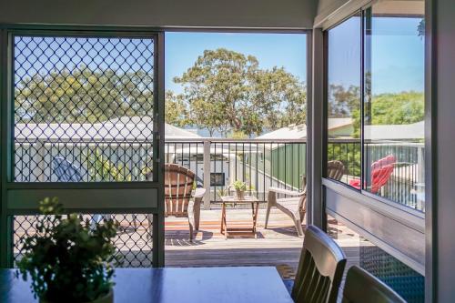 a balcony with a view of a table and chairs at Welcome to BAY 13 in Tin Can Bay
