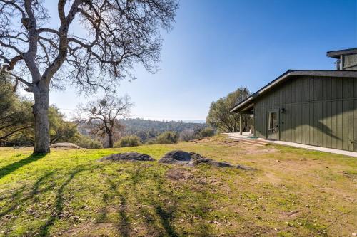 a house with a tree and rocks in a field at Rocky Ridge Cabin Yosemite in Coarsegold