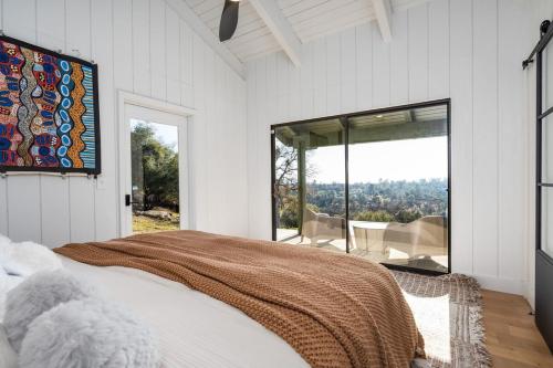a bedroom with a bed and a large window at Rocky Ridge Cabin Yosemite in Coarsegold