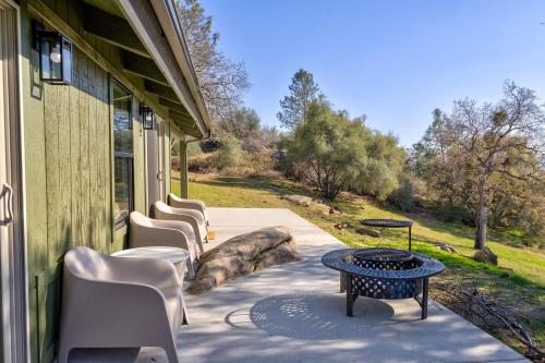 a row of chairs and a table on a porch at Rocky Ridge Cabin Yosemite in Coarsegold