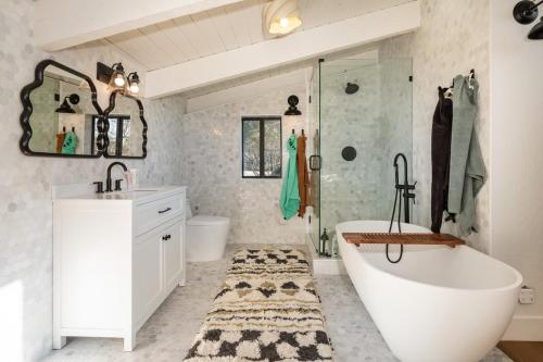 a bathroom with a tub and a sink and a shower at Rocky Ridge Cabin Yosemite in Coarsegold