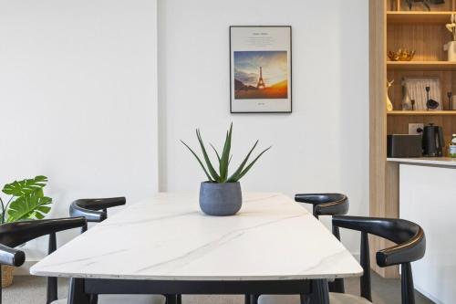 a white table with a potted plant on it at Waterview 1bedroom Plus Study Room at Wentworth Point in Sydney