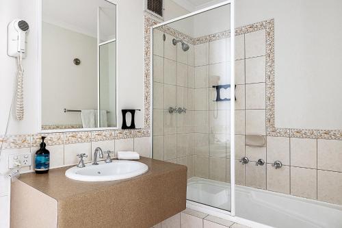a bathroom with a sink and a shower at Retreat Horizons - Spacious Perth CBD 1BR in Perth