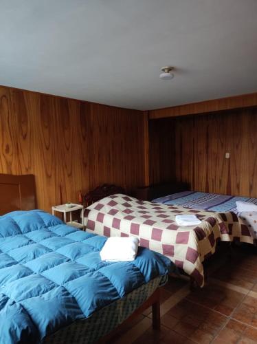 dwa łóżka ustawione obok siebie w pokoju w obiekcie Habitación familiar en el centro de Puno w mieście Puno