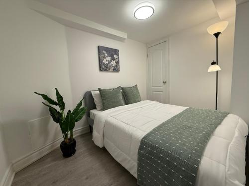 a bedroom with a bed and a potted plant at Modern 2BR in the Heart of Little Italy in Toronto
