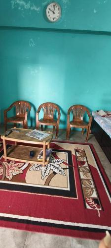 sala de estar con mesa, sillas y reloj en Daya Home Stay 1 km to Sangam Mahakumbh, en Prayagraj