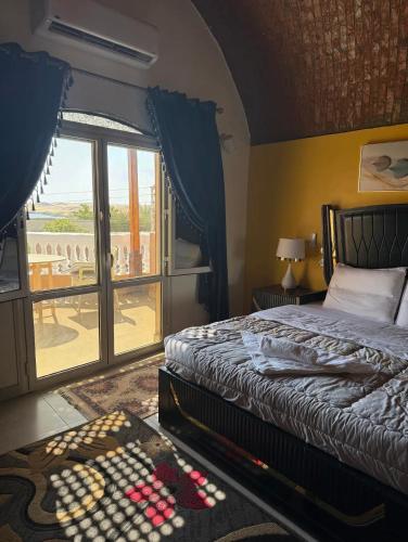 a bedroom with a bed and a view of a patio at Abu simbel Nubian Guest House in Abu Simbel