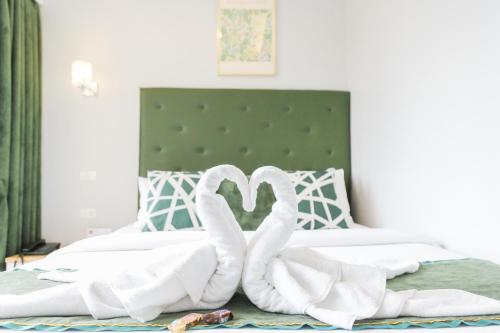 two white swans are folded up on a bed at Pacific Bay Grand Suites in Manila