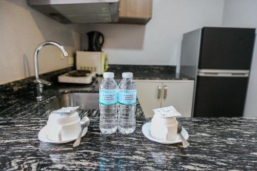 two bottles of water sitting on a kitchen counter at Pacific Bay Grand Suites in Manila
