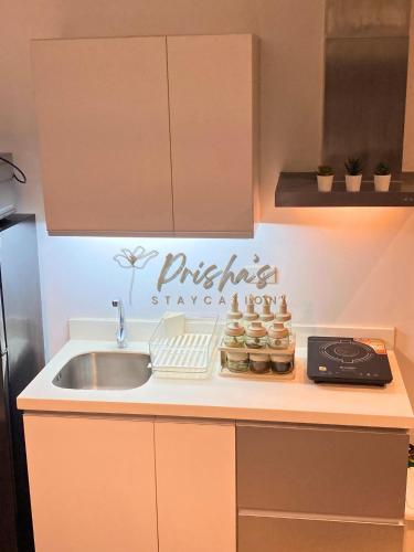 a kitchen with a sink and a kitchen sign on the wall at Prisha Staycation in Manila